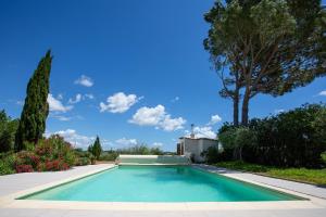 una piscina en un patio con un árbol en Le Petit Viala, en Capestang