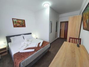 a hotel room with a bed and a wooden table at Hotel Decebal Eforie Nord in Eforie Nord +40 photos