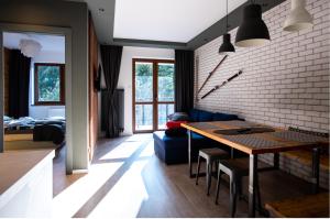 kuchnia i jadalnia ze ścianą z cegły w obiekcie Apartament ZIELONA w mieście Krynica Zdrój