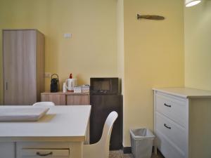 a room with a table and a kitchen with a refrigerator at 2 passi dal mare in Finale Ligure