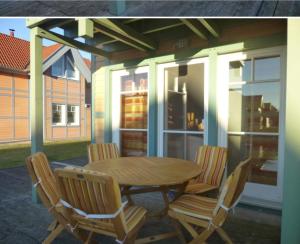 a wooden table and chairs on a patio at Ferienhaus ˋLichtblickˋ in Rheinsberg