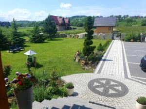 Elle offre une vue sur un jardin avec une allée et une pelouse. dans l'établissement Kryształowy Dworek, à Szaflary