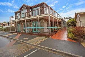 a wooden house on a street in front of a building at Port Central No 4 in Port Campbell