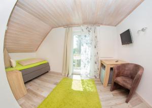 a small room with a bed and a desk and a window at Pension Sigle in Dingolfing
