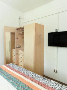 1 dormitorio con 1 cama y TV en la pared en Folly Vacation 204 Getaway perfect place to relax & unwind, en Folly Beach