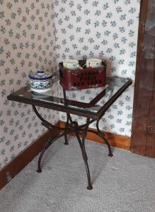 a glass table with two bowls and a box on it at LE CHALET SUISSE - Chambre aux fleurs in Le Vicel