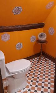 an orange bathroom with a toilet and a table at LE CHALET SUISSE - Chambre aux fleurs in Le Vicel