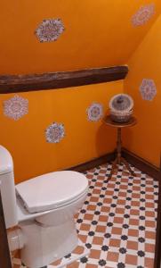 La salle de bains orange est pourvue de toilettes et d'une table. dans l'établissement LE CHALET SUISSE - Chambre aux fleurs, à Le Vicel