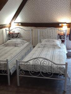 two beds sitting next to each other in a bedroom at LE CHALET SUISSE - Chambre aux fleurs in Le Vicel