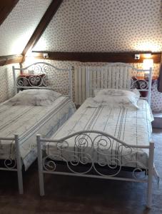 dos camas sentadas una al lado de la otra en un dormitorio en LE CHALET SUISSE - Chambre aux fleurs, en Le Vicel