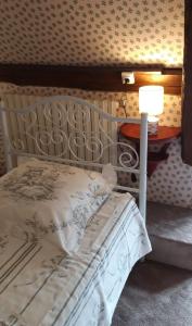 1 dormitorio con 1 cama y 1 mesa con lámpara en LE CHALET SUISSE - Chambre aux fleurs, en Le Vicel