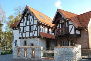 a black and white house with a brick at Domki Hallerowka Resort in Władysławowo