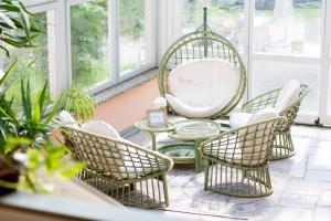 een kamer met stoelen, een tafel en een schommel bij Pension Sigle in Dingolfing