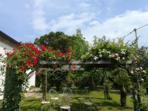 a garden with a wooden pergola with red roses at Casa Pianta in Cavallino-Treporti