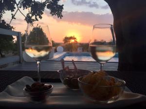 una mesa con dos copas de vino y un tazón de comida en Pantanelli Di Vendicari en Casa Maccari