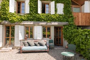 un divano seduto di fronte a un edificio ricoperto di edera di Wonderlandscape Guest House a Ginevra