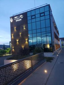 a large glass building with lights in front of it at Panorama Business Inn in Cluj-Napoca