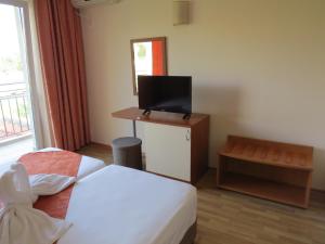 Cette chambre comprend deux lits et une télévision. dans l'établissement Family Hotel Dayana Beach, à Sinemorets