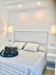 - une chambre blanche avec un lit et un porte-monnaie dans l'établissement Hotel Sirena - Servizio spiaggia inclusive, à Peschici