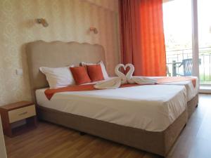 ein Schlafzimmer mit einem Bett mit einer Schleife darauf in der Unterkunft Family Hotel Dayana Beach in Sinemorets