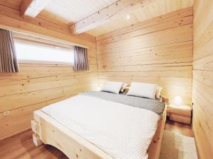 a bedroom with a bed in a wooden room at Log House Natura in Radovljica