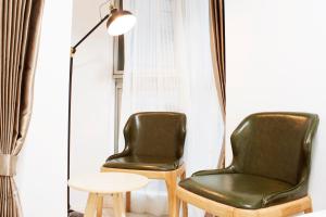 two green chairs next to a table and a lamp at Hotel Shu in Tokyo