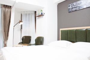 a meeting room with two green chairs and a table at Hotel Shu in Tokyo