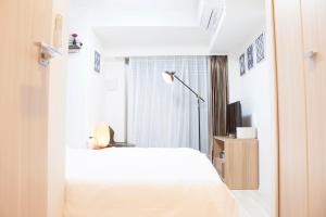 a bedroom with a white bed and a window at Hotel Shu in Tokyo