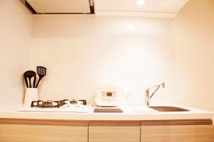 a kitchen with a sink and a microwave at Hotel Shu in Tokyo
