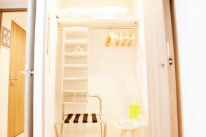 a closet with white shelves and a chair in it at Hotel Shu in Tokyo