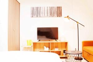 Hotel Shu في طوكيو: غرفة معيشة مع تلفزيون وأريكة