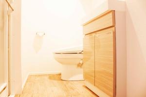 a bathroom with a toilet and a wooden cabinet at Hotel Shu in Tokyo