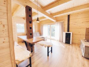 Cette chambre en bois dispose d'une table et d'une cheminée. dans l'établissement Log House Natura, à Radovljica