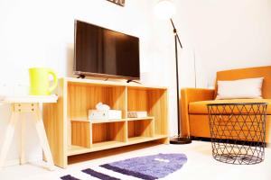 a living room with a television on a wooden entertainment center at Hotel Shu in Tokyo