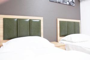 two beds with green headboards in a bedroom at Hotel Shu in Tokyo