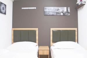 two beds in a room with white sheets at Hotel Shu in Tokyo