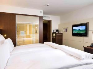 科隆的住宿－鉑爾曼科隆酒店，卧室配有一张白色大床和电视。