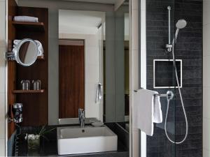 a bathroom with a sink and a shower at Pullman Cologne in Cologne