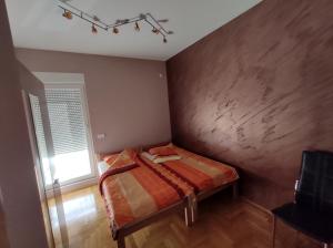 ein kleines Schlafzimmer mit einem Bett und einem Fenster in der Unterkunft Apartment StefanA in Belgrad