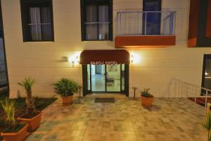 Saatlı Hotel في تشيشمي: مدخل إلى مبنى يوجد أمامه نباتات الفخار