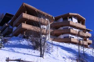 un edificio en la cima de una colina nevada en Residenz Berghof Mösern en Seefeld in Tirol