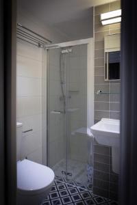 a bathroom with a shower and a toilet and a sink at The Eaton Townhouse in London