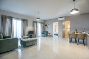 een woonkamer met een bank en een tafel en stoelen bij Olivia Suite in Agios Nikolaos