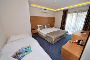 a hotel room with two beds and a table at Saatlı Hotel in Çeşme