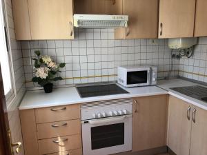 een keuken met een kookplaat, een oven en een magnetron bij Bubu Beach 5 Ático in Los Cristianos +23 foto's