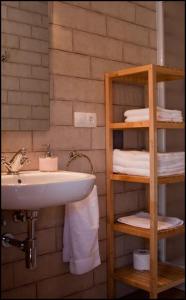 a bathroom with a sink and a shelf with towels at Apartamentos Barrena in Albarracín