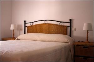 a bedroom with a large bed with two lamps at Apartamentos Barrena in Albarracín