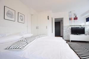 biała sypialnia z dużym łóżkiem i telewizorem w obiekcie Elegant Apartment Warsaw View w Warszawie