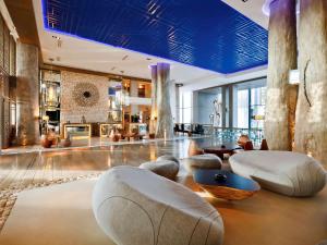 un hall avec des chaises et des tables ainsi qu'un plafond bleu dans l'établissement Sofitel Essaouira Mogador Golf & Spa, à Essaouira