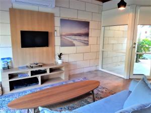 a living room with a tv on a wall at Port Central No 4 in Port Campbell